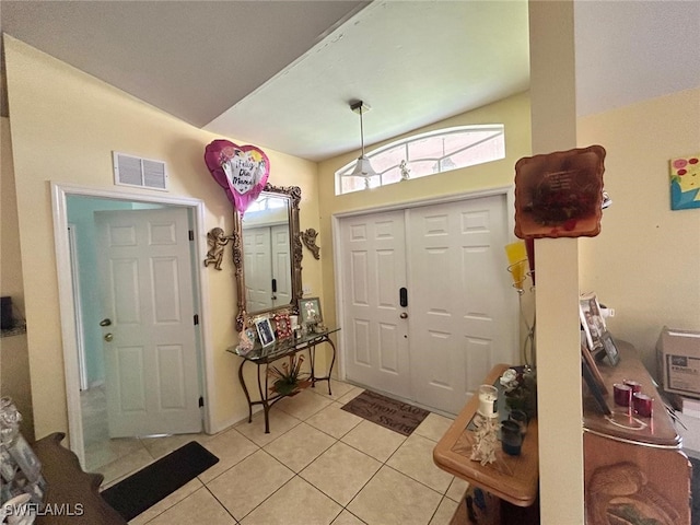 foyer featuring vaulted ceiling and light tile patterned flooring