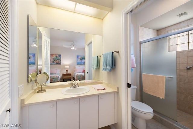 bathroom featuring vanity, toilet, an enclosed shower, and ceiling fan