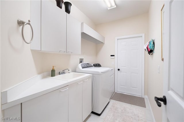 laundry room with separate washer and dryer, sink, light tile patterned flooring, and cabinets