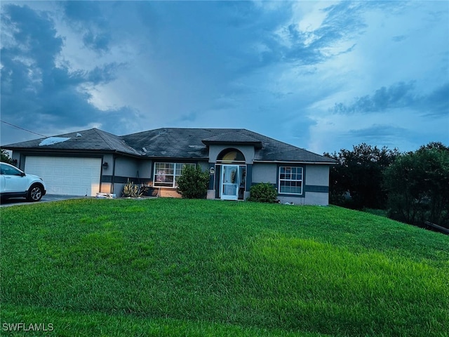 single story home with a front yard and a garage