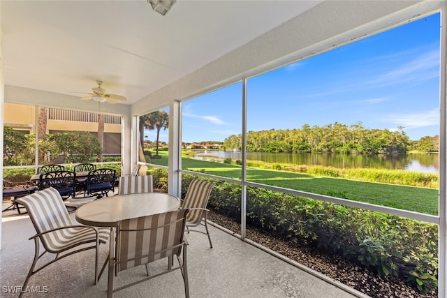 sunroom featuring a water view and ceiling fan