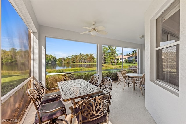 sunroom / solarium featuring a water view and ceiling fan