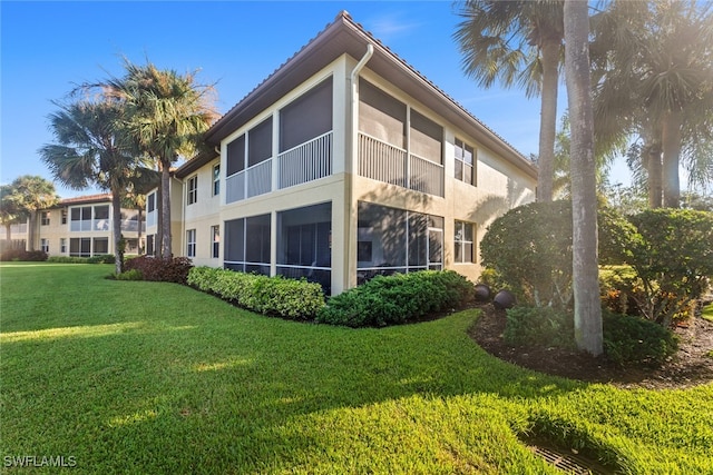 back of house featuring a sunroom and a yard