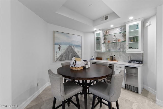 dining space featuring beverage cooler and bar