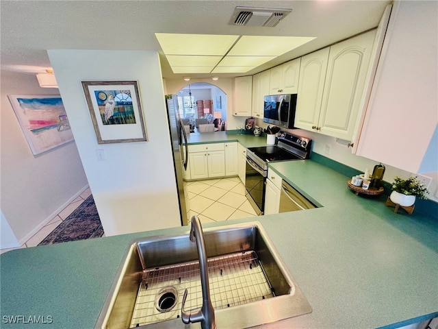 kitchen with sink, light tile patterned floors, appliances with stainless steel finishes, and white cabinetry