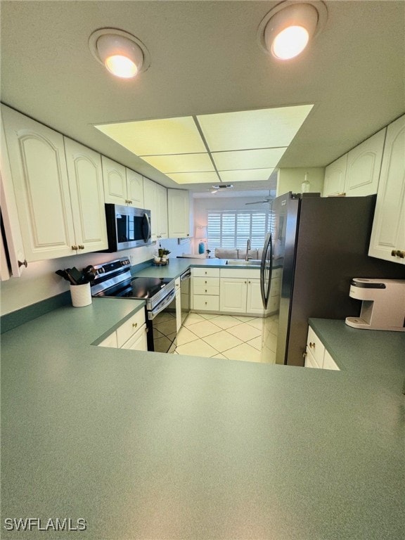 kitchen featuring light tile patterned floors, sink, stainless steel appliances, and white cabinets