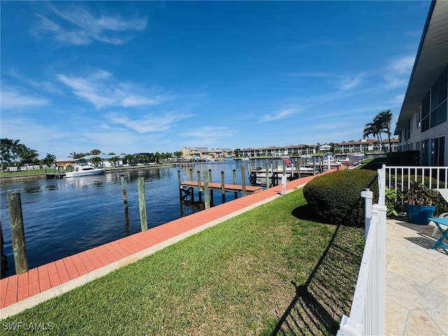 view of dock featuring a lawn and a water view