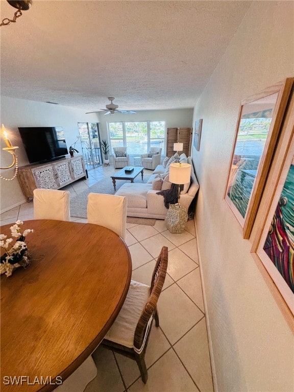 tiled dining area featuring a textured ceiling and ceiling fan