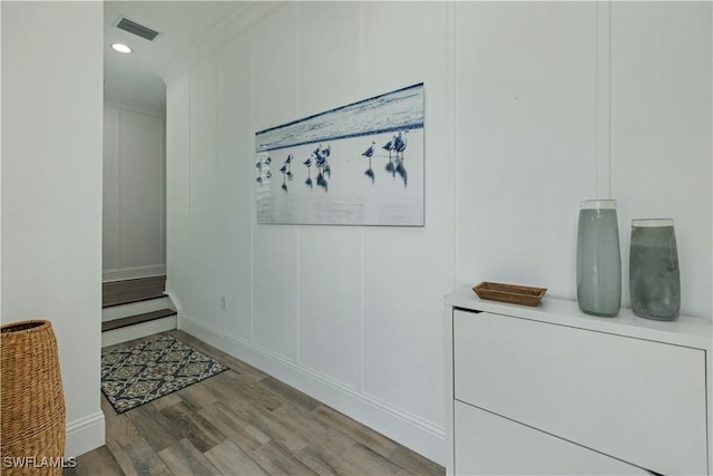 corridor featuring light hardwood / wood-style floors and crown molding