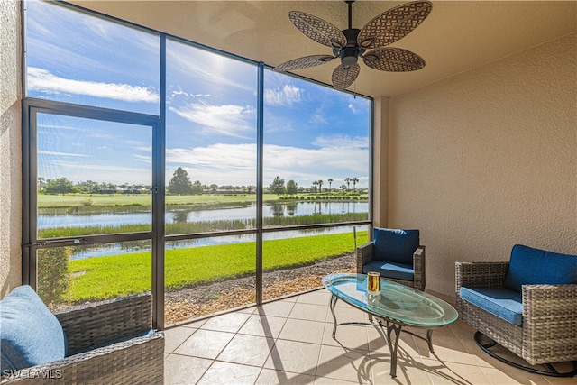 sunroom featuring a water view, ceiling fan, and plenty of natural light