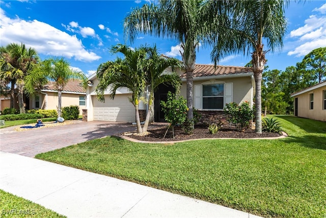 mediterranean / spanish home featuring a garage and a front lawn