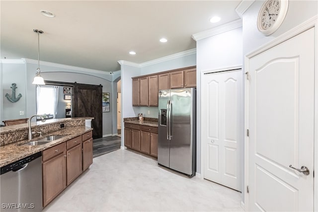 kitchen with dark stone countertops, crown molding, appliances with stainless steel finishes, sink, and pendant lighting