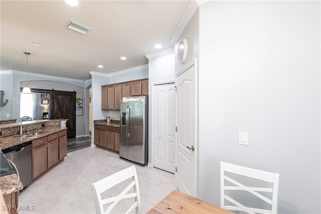 kitchen with decorative light fixtures, appliances with stainless steel finishes, sink, dark stone counters, and ornamental molding