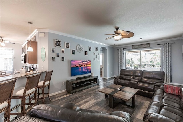 living room featuring ornamental molding, dark hardwood / wood-style flooring, plenty of natural light, and ceiling fan