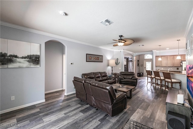 living room with crown molding, dark hardwood / wood-style flooring, sink, and ceiling fan