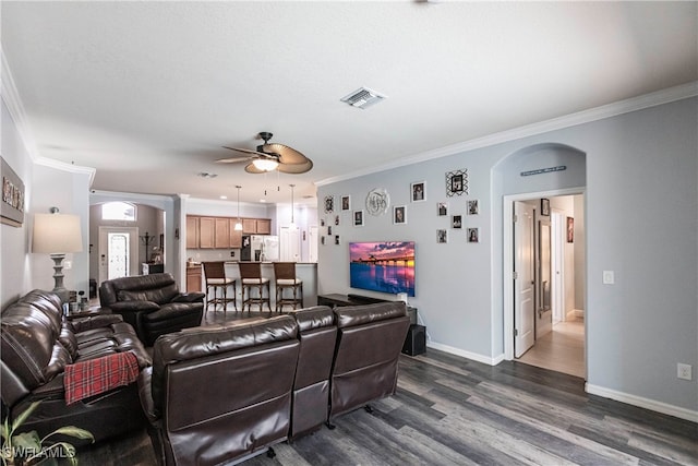 living room featuring ceiling fan, dark hardwood / wood-style floors, and ornamental molding