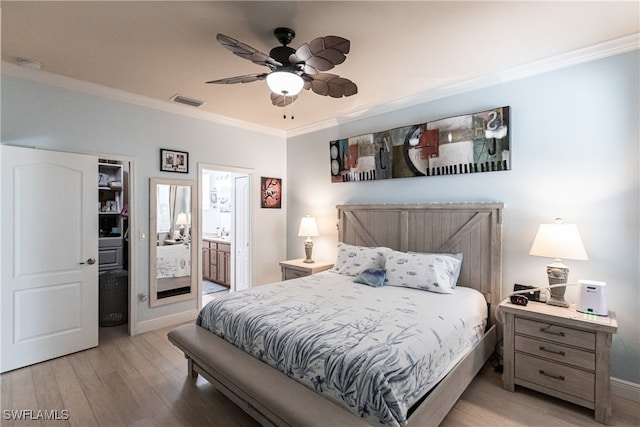 bedroom with connected bathroom, ornamental molding, light wood-type flooring, and ceiling fan