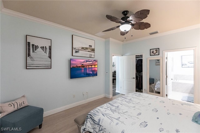 bedroom with crown molding, ceiling fan, and ensuite bath