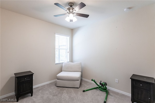 living area with light colored carpet and ceiling fan