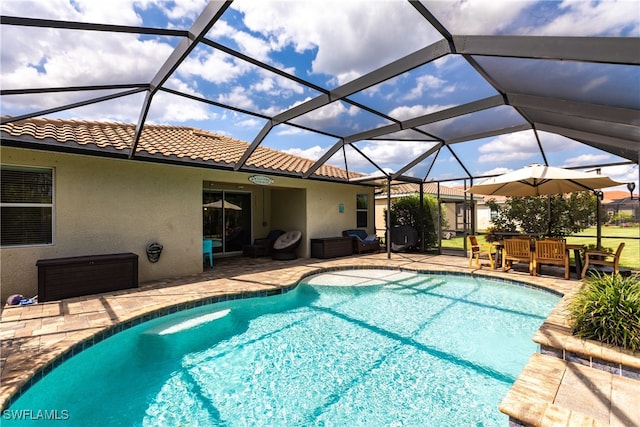 view of pool with a patio area and glass enclosure