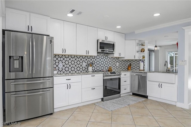 kitchen featuring sink, light tile patterned floors, appliances with stainless steel finishes, light stone counters, and white cabinets