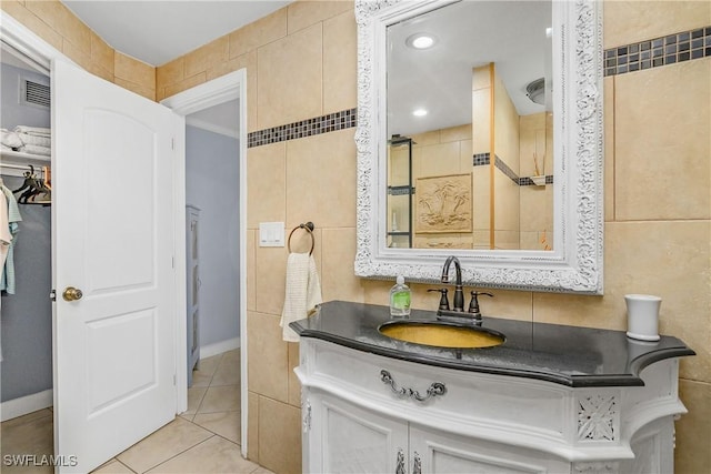 bathroom with tile patterned floors, vanity, and tile walls