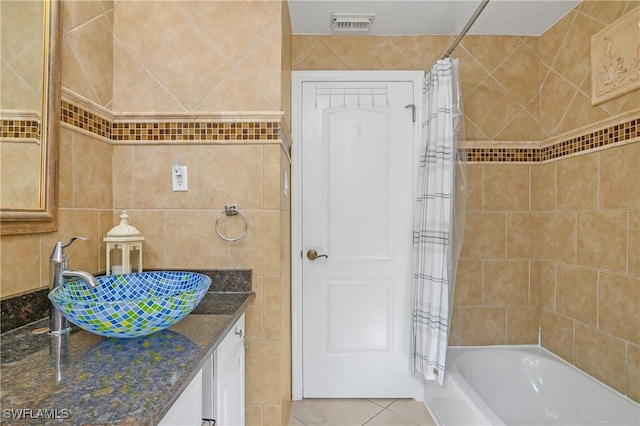 bathroom with vanity, tile walls, tile patterned floors, and shower / bath combo with shower curtain