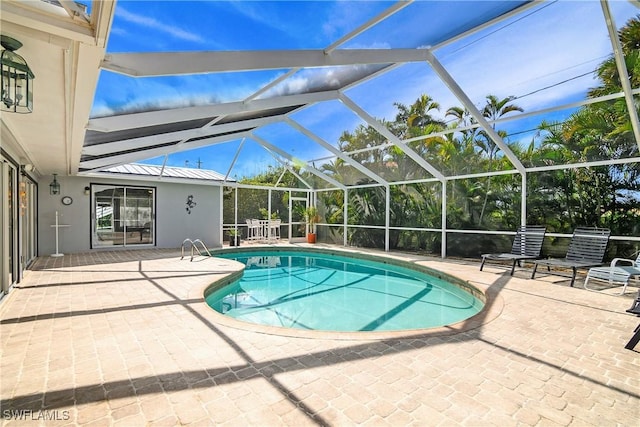 view of swimming pool featuring a lanai and a patio area