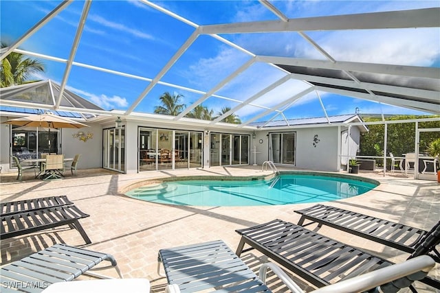 view of swimming pool with a lanai and a patio