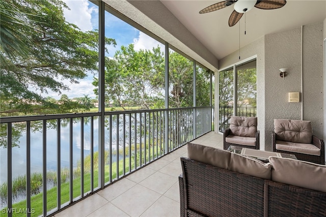 sunroom / solarium featuring a wealth of natural light, ceiling fan, and a water view