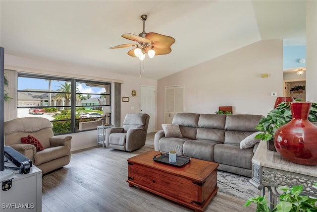 living room featuring light hardwood / wood-style flooring, vaulted ceiling, and ceiling fan