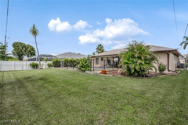 view of yard with a lanai and central AC