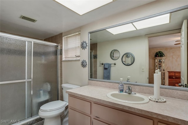 bathroom featuring vanity, toilet, and a shower with shower door