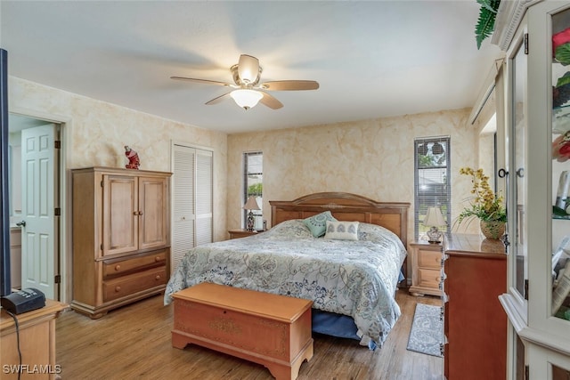 bedroom featuring light wood-type flooring, ceiling fan, and a closet