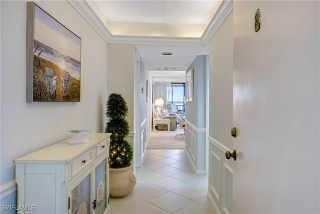 hall featuring a tray ceiling and light tile patterned floors