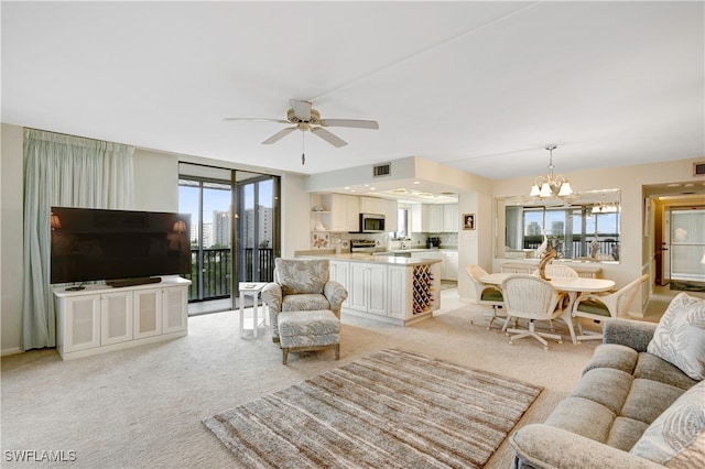 living room with ceiling fan with notable chandelier, a wealth of natural light, and light carpet