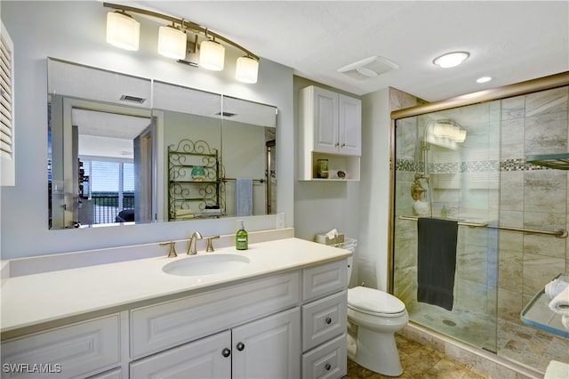 bathroom featuring vanity, toilet, and an enclosed shower