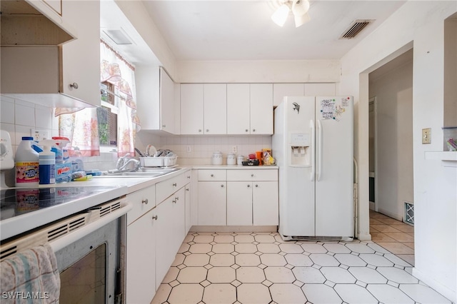 kitchen with decorative backsplash, white cabinets, white appliances, and sink