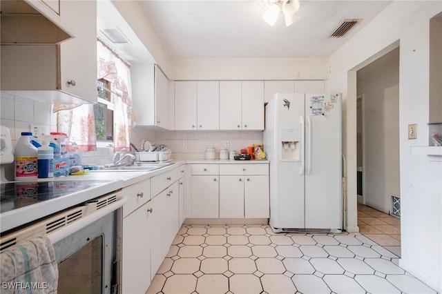 1208 Barnsdale St, Lehigh Acres, FL 33936 - kitchen featuring white appliances, light countertops, decorative backsplash, white cabinets, and under cabinet range hood