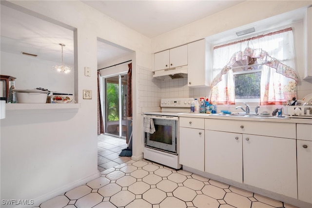 kitchen featuring electric range, sink, a notable chandelier, white cabinetry, and decorative backsplash