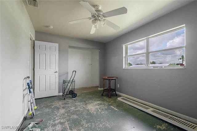 unfurnished bedroom featuring a baseboard heating unit and ceiling fan