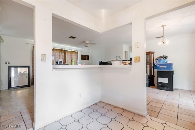 kitchen with ceiling fan with notable chandelier and kitchen peninsula