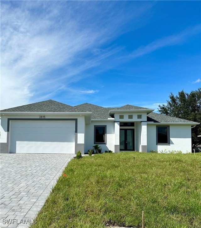 prairie-style home with a garage and a front yard