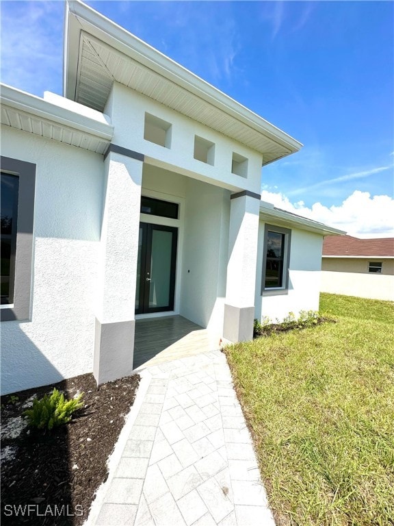 entrance to property with a lawn