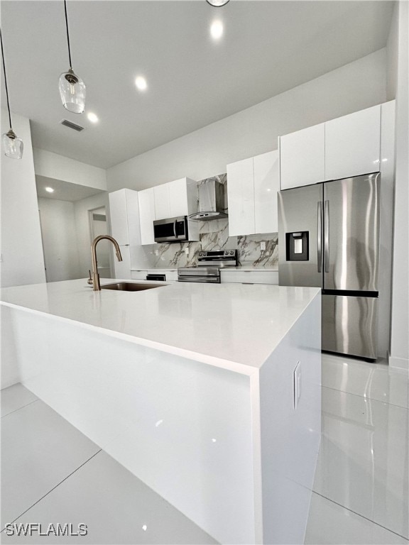 kitchen featuring pendant lighting, appliances with stainless steel finishes, white cabinetry, and a spacious island