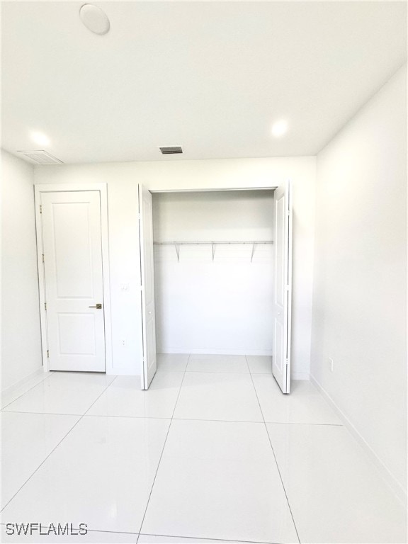 unfurnished bedroom featuring a closet and light tile patterned floors