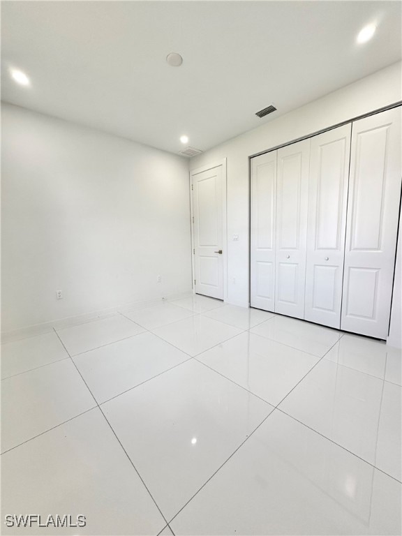 unfurnished bedroom with a closet and light tile patterned floors