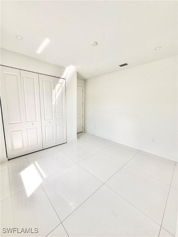 interior space with light tile patterned floors and a closet