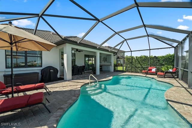 view of swimming pool featuring a patio, ceiling fan, and glass enclosure