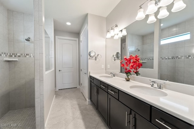 bathroom with tile patterned floors, vanity, and tiled shower